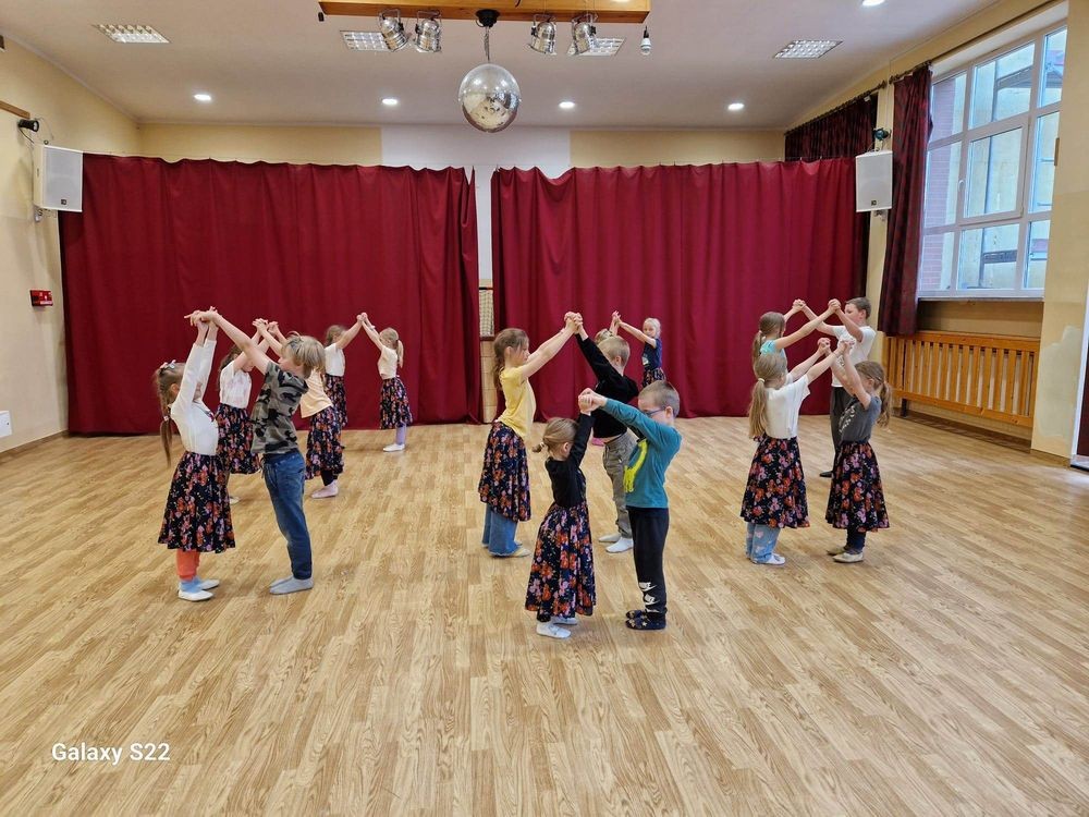 dzieci trenujące układ taneczny w strojach regionalnych